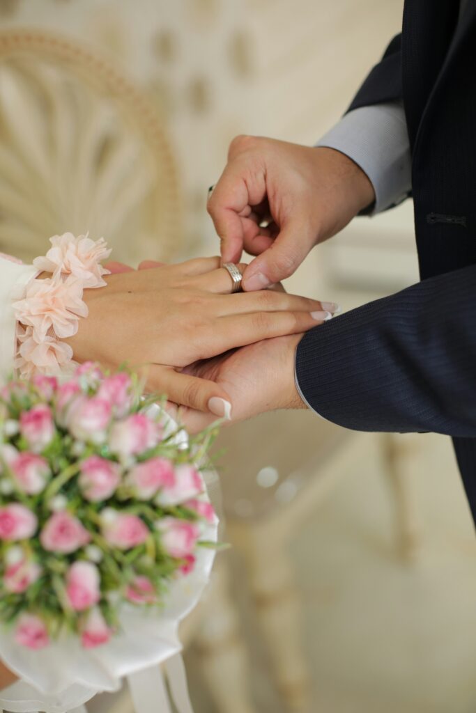 Hands exchanging wedding rings during ceremony